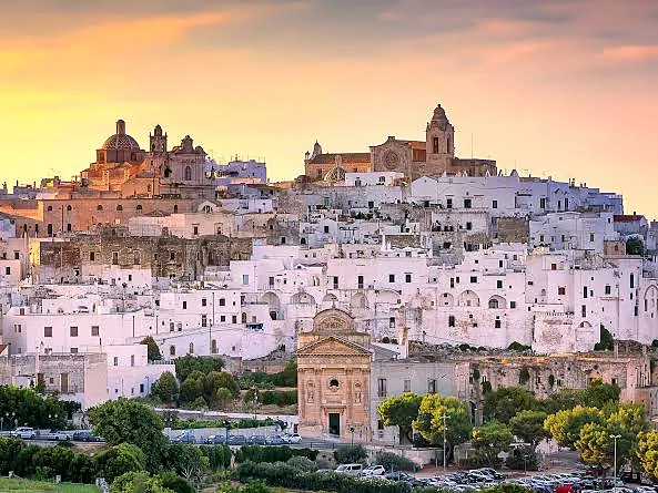 Ostuni al tramonto: le case bianche salgono fino alla cattedrale in cima al colle.